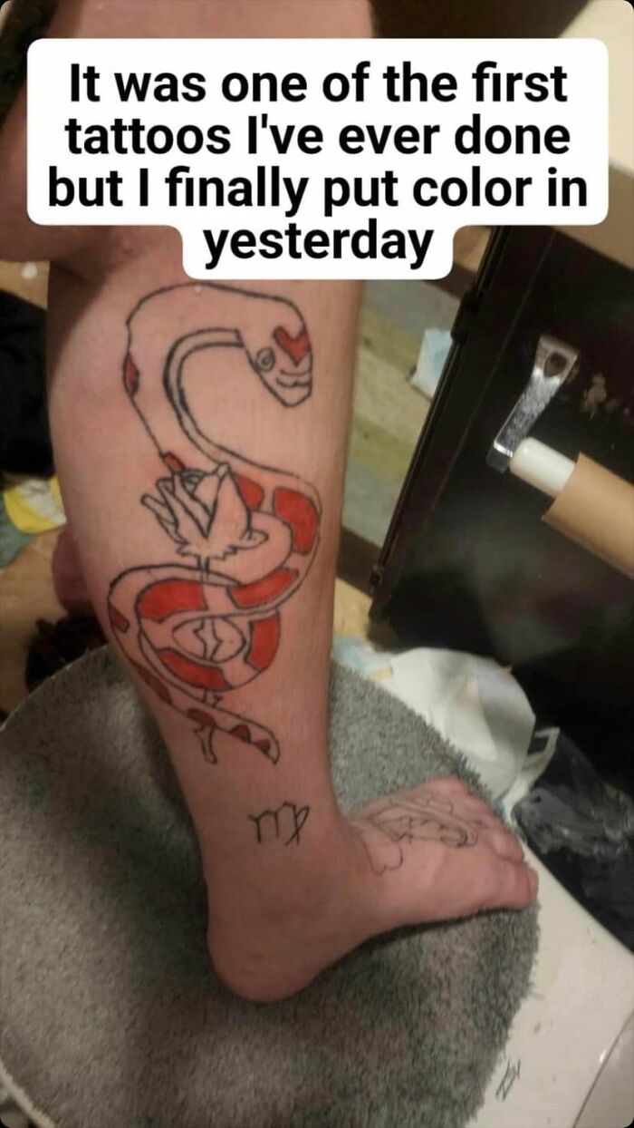Snake tattoo on leg with red color, highlighting one of the many horrible tattoo choices shared in a Facebook group.