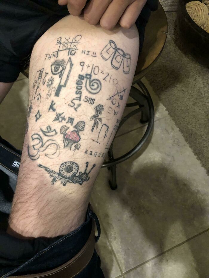 Unusual tattoo designs on a person's leg, featuring random symbols and numbers.