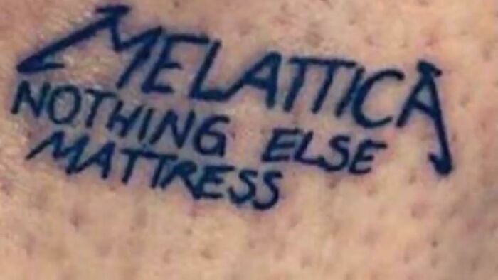 Tattoo with text "MELATTICA NOTHING ELSE MATTRESS" in bold, black letters on skin, showcasing a worst tattoos example.