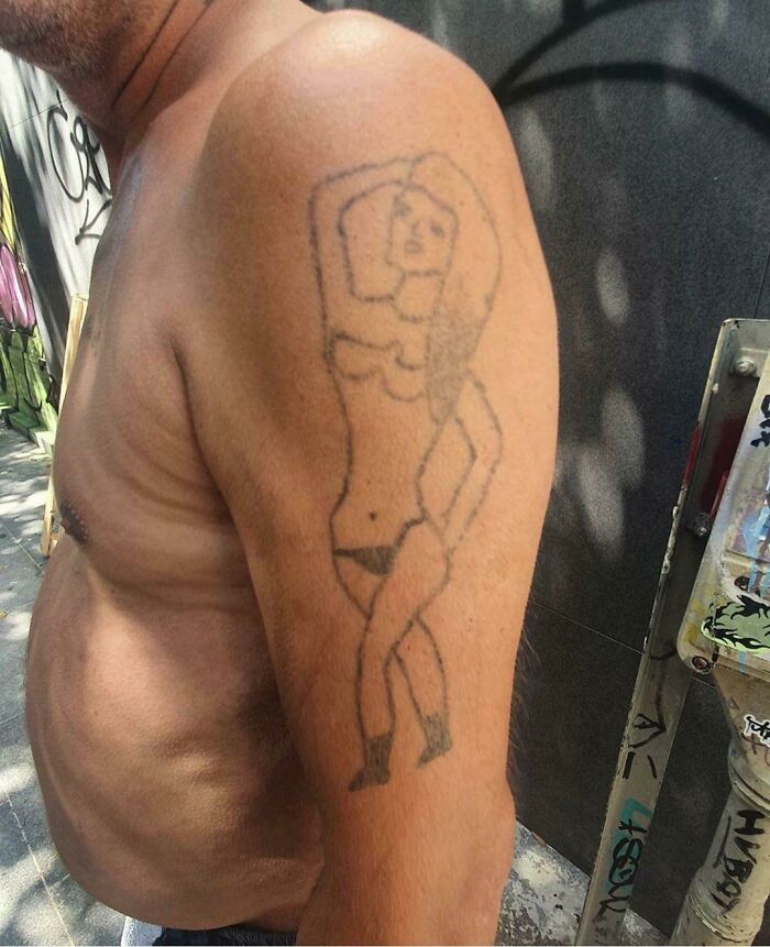 Man with one of the worst tattoos on his arm featuring an abstract figure drawing.