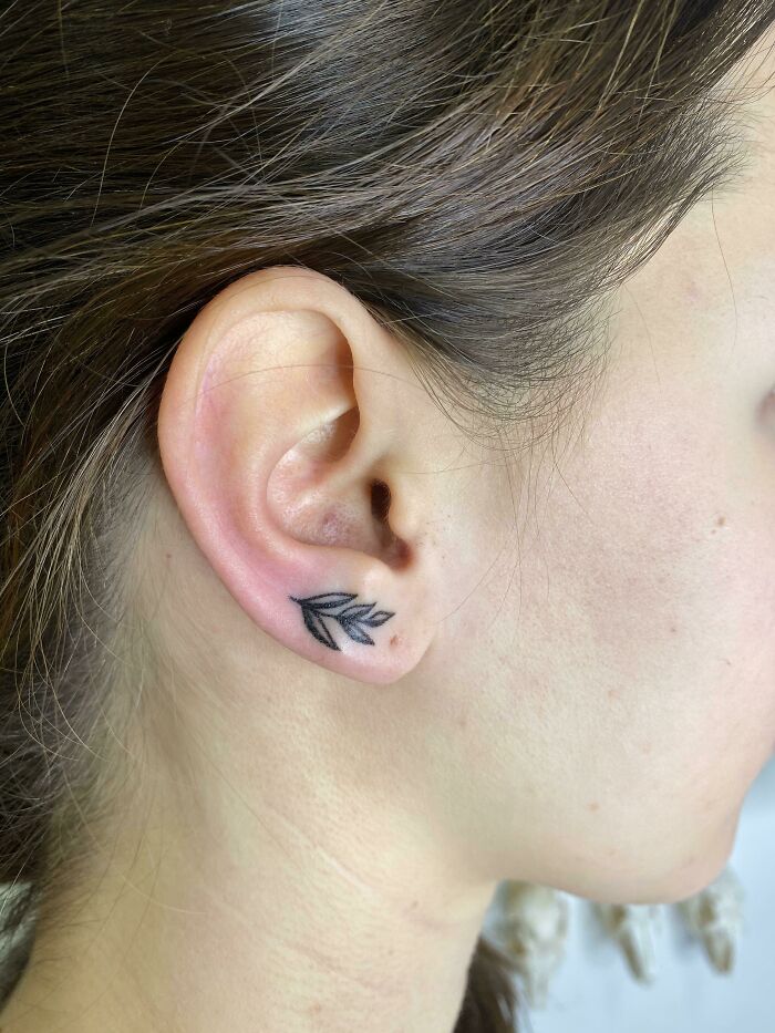 Minimalistic leaf ear tattoo design on a person's inner ear.