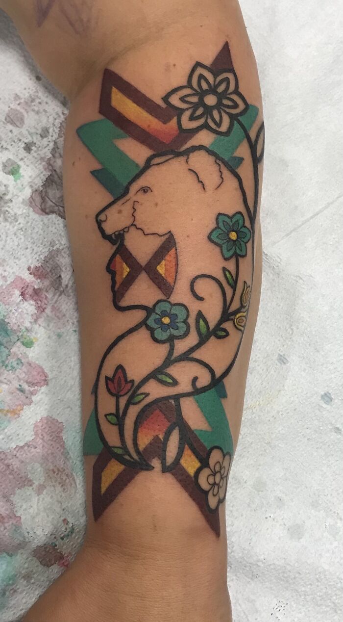 Colorful bear and floral design tattoo on arm, showcasing latest body art.
