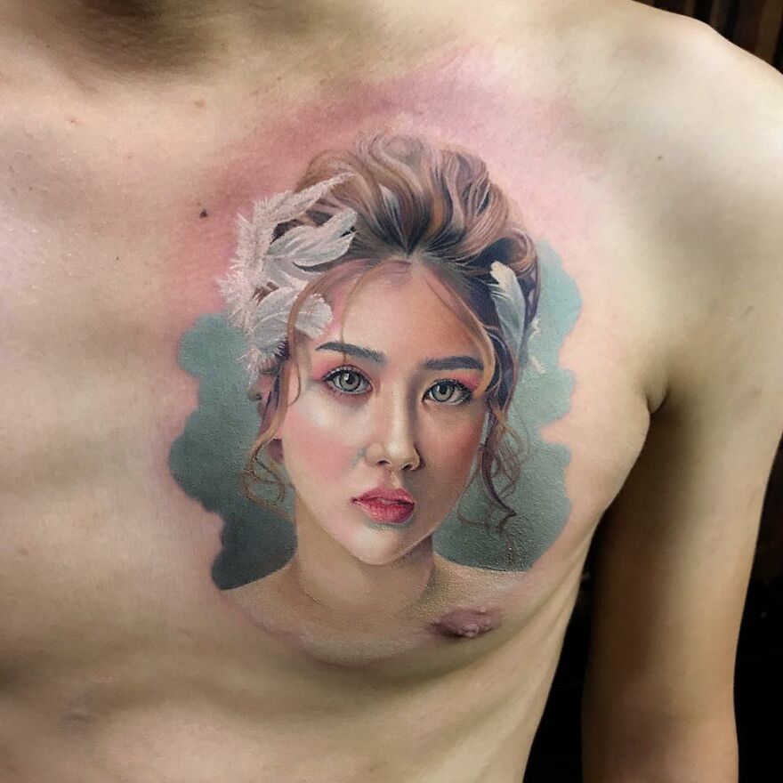 Hyper-realistic tattoo portrait on a person's chest, detailed with vivid colors and lifelike features.