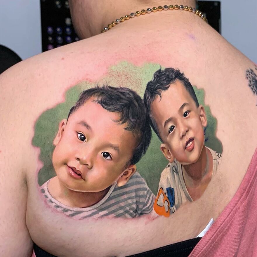 Hyper-realistic tattoo of two children on a person's back, showcasing vivid colors and lifelike detail.