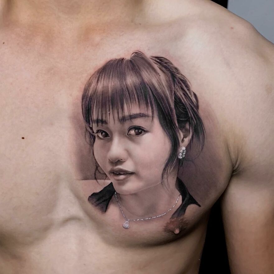 Hyper-realistic tattoo of a woman's face on a man's chest, showcasing detailed artistry.