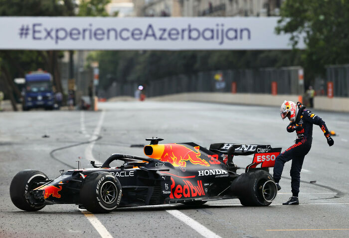 Formula 1 driver celebrating beside a Red Bull racing car during an iconic sports moment in 2022 sports photography awards.