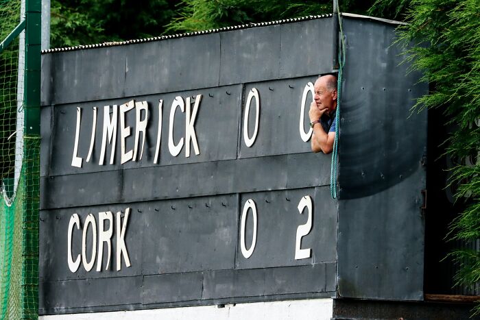 Scoreboard showing Limerick 0-0 and Cork 0-2 with a man leaning out, capturing a key moment in sports in 2022.