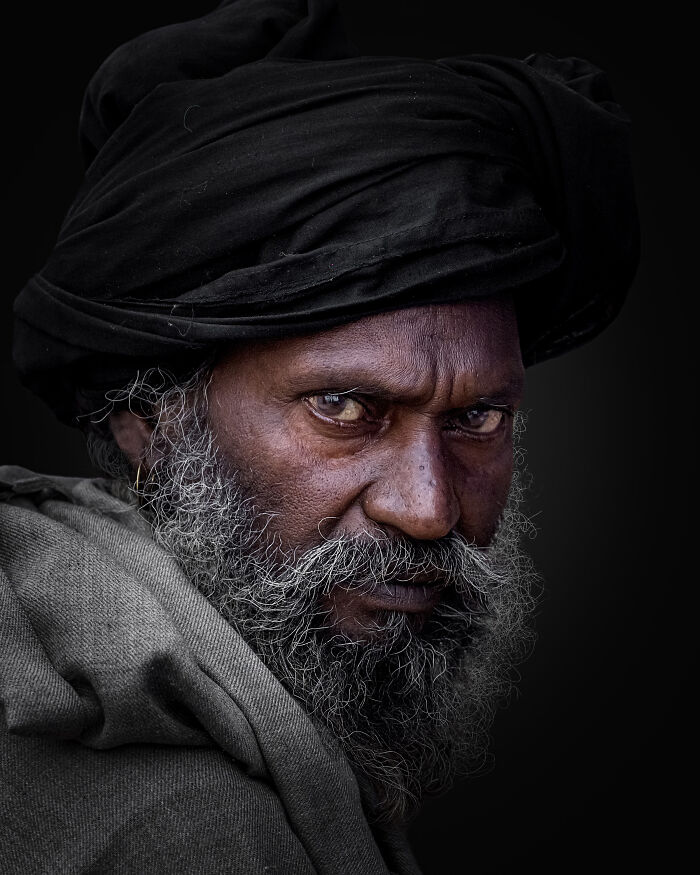 Close-up portrait of a bearded man wearing a black turban, showcasing one of the most powerful portraits by photographers worldwide.