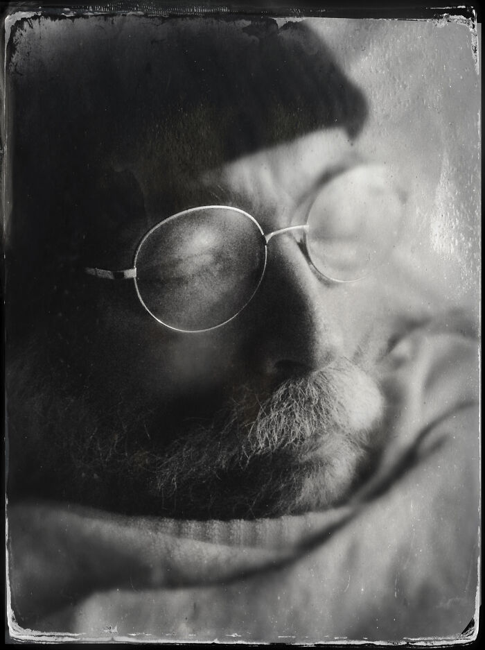 Black and white portrait of a man with glasses and a beard, showcasing powerful portrait photography from around the world.