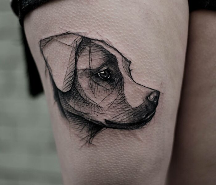 Pet tattoo of a dog's face in sketch style on skin, symbolizing the bond between humans and pets.