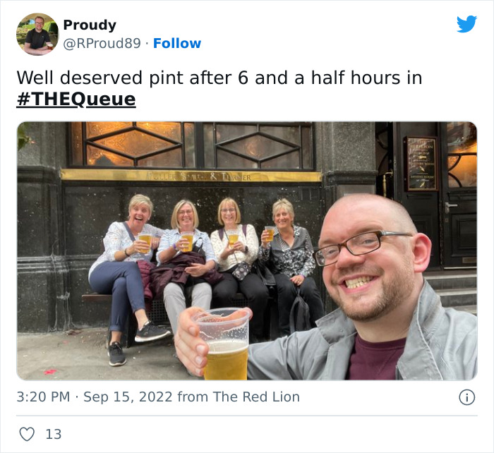 Group of friends smiling and holding pints, celebrating after waiting in the very British queue in London.
