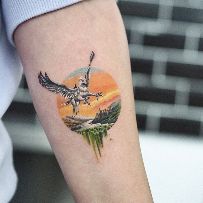 Harry Potter tattoo featuring a flying hippogriff against a colorful background on an arm.