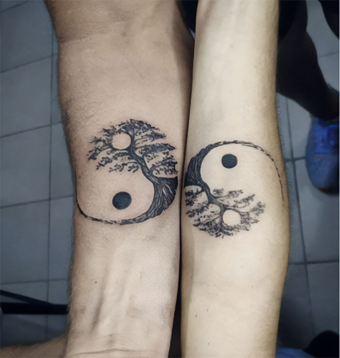 Sibling tattoos featuring interconnected Yin-Yang designs on forearms symbolizing brother and sister bond.