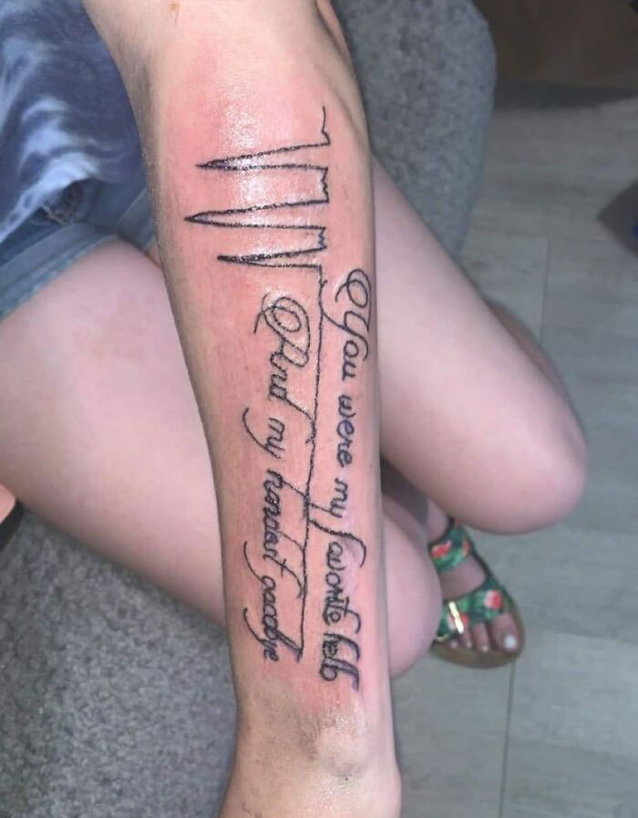 A forearm with a misspelled tattoo reading "You were my favorite hello" alongside heartbeat lines.
