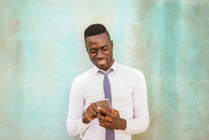 Man wearing white shirt and holding phone