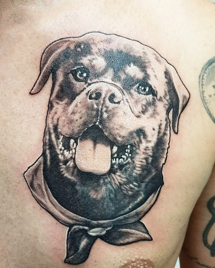 Pet tattoo of a joyful dog with tongue out, wearing a bandana, showcasing love for furry friends.