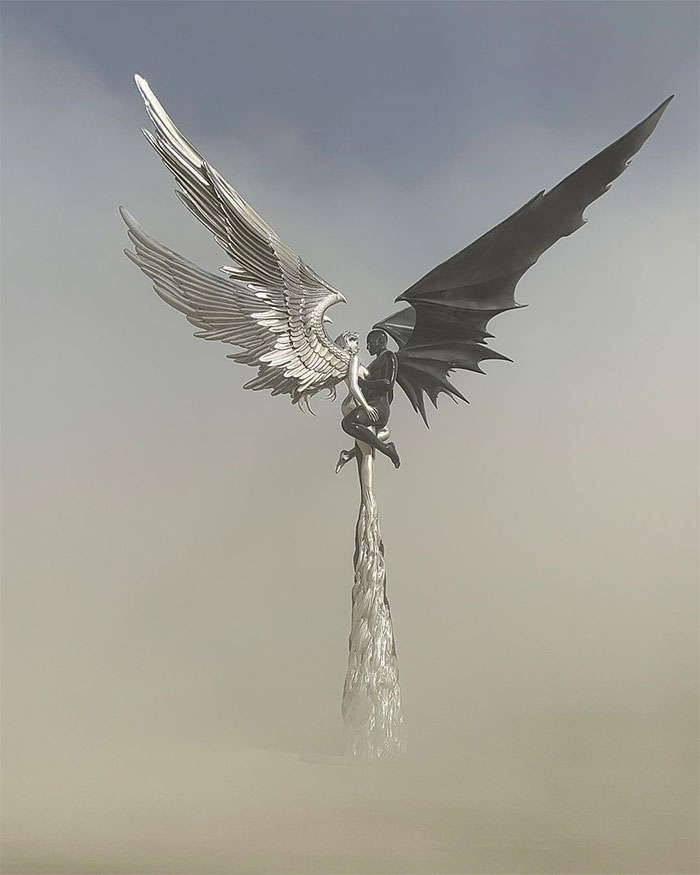 Statue of black male angel holding silver female angel