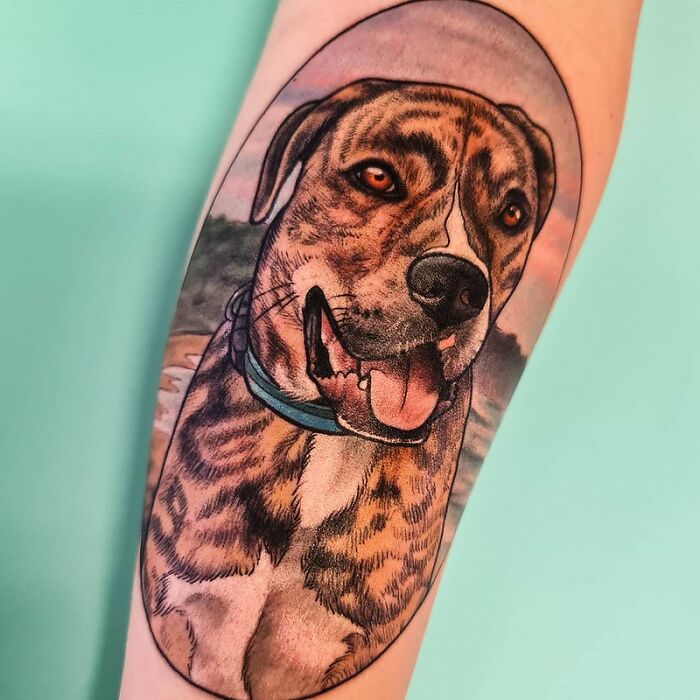 Tattoo of a smiling dog on an arm, celebrating the bond between humans and their pets.