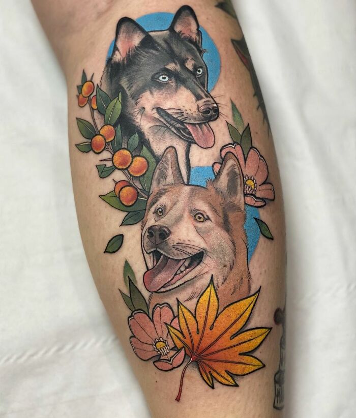 Pet tattoos featuring two dogs surrounded by flowers and leaves, celebrating furry friends.