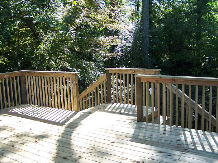 Wooden deck with railings in a sunny forest setting illustrating entertaining it doesn't work like that stories by professionals.