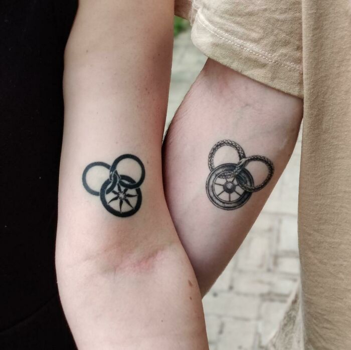 Brother and sister tattoos on forearms with interlocking ring designs.