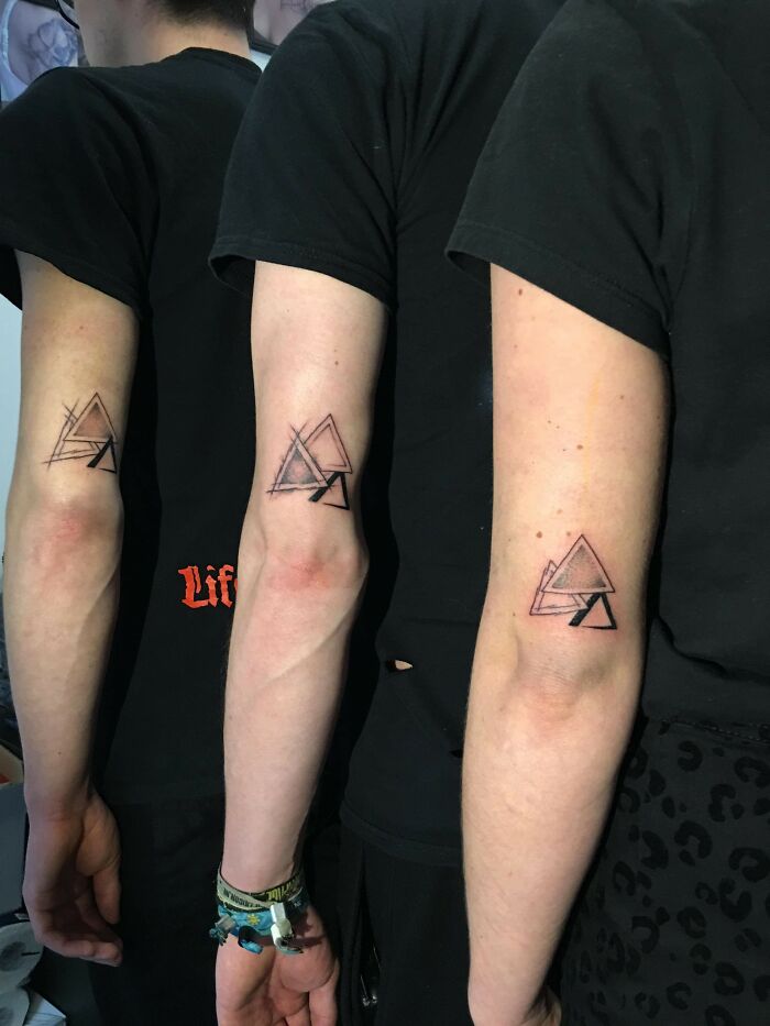 Three siblings with matching geometric tattoos on their arms, showcasing simple brother and sister tattoo ideas.