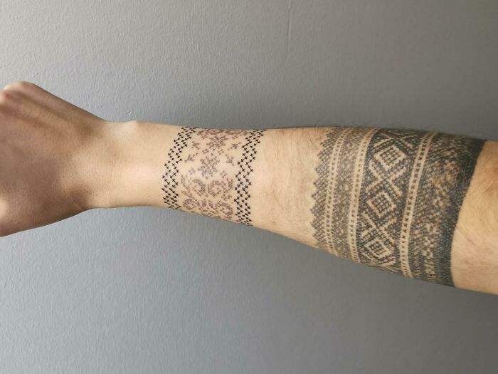 Intricate armband tattoos featuring geometric and tribal designs on a forearm.