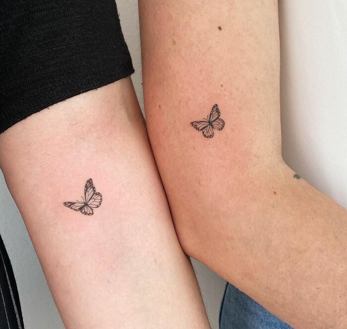 Butterfly BFF tattoos on two arms, symbolizing friendship and shared memories.