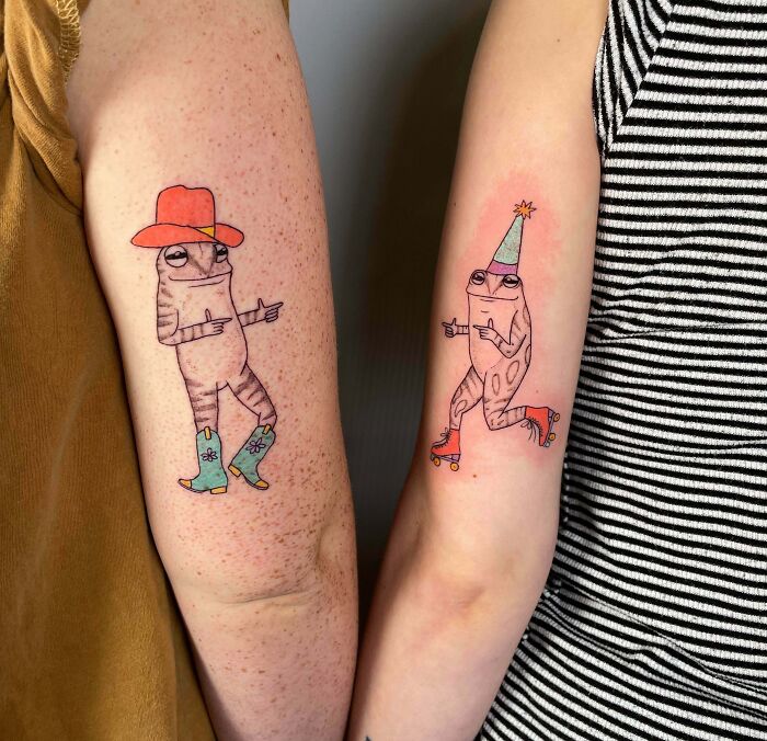 Two matching frog BFF tattoos, one wearing a cowboy hat, the other a party hat, showcasing friendship through silly art.