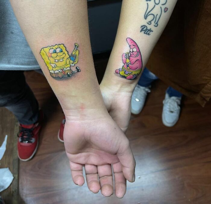 BFF tattoos of cartoon characters on forearms, symbolizing friendship and shared adventures.