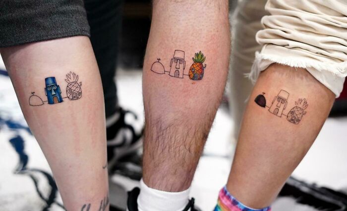 Three legs with small brother and sister tattoos of cartoonish figures and pineapples, showcasing simple tattoo ideas.