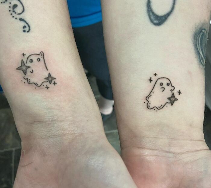 Ghost-themed best friend tattoos on forearms, symbolizing friendship and connection.
