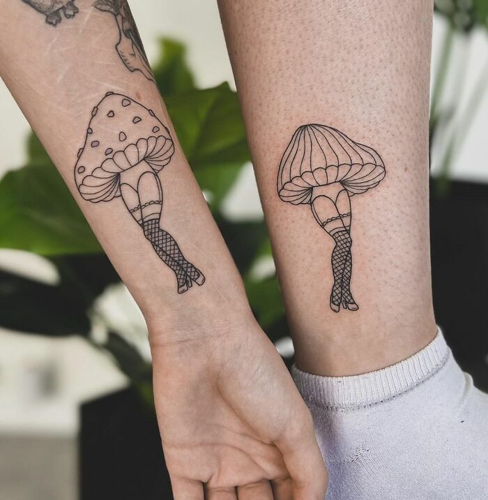 Tattoos of mushrooms with legs on friends' arms to commemorate friendship.