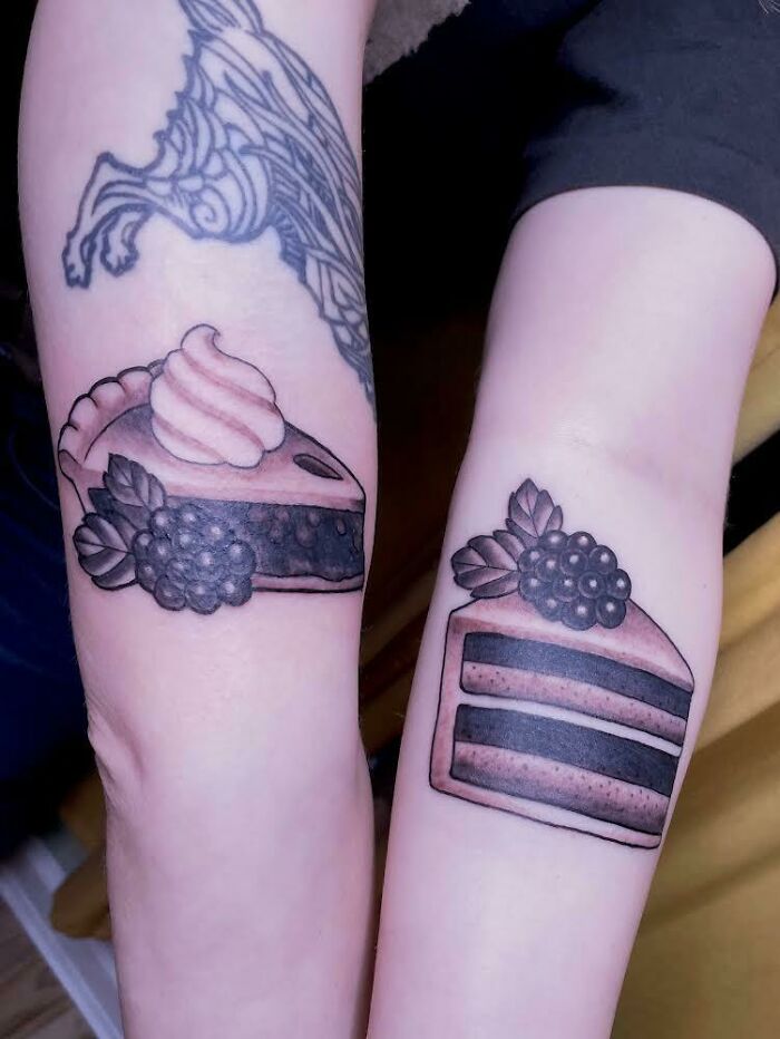Matching cake slice tattoos on two arms, symbolizing best friend tattoos for friendship.