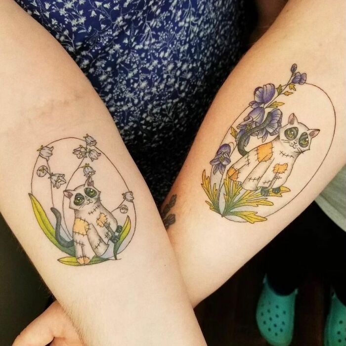 Matching best friend tattoos featuring whimsical cats and floral designs on two forearms.