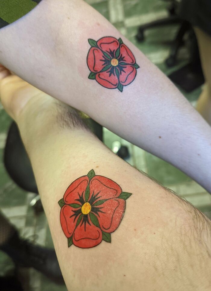 Matching floral tattoos on arms symbolizing best friends' bond.
