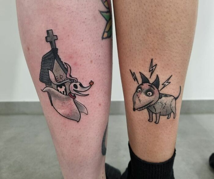 Cartoon dog tattoos on two legs, showcasing unique best friend tattoo designs.