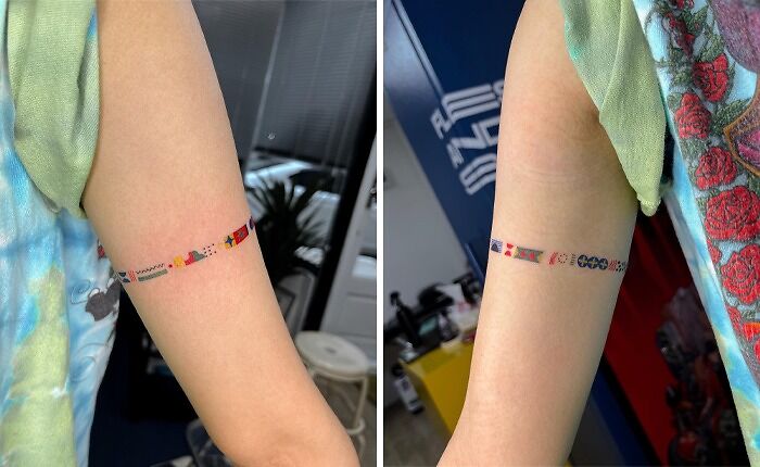 Colorful armband tattoo with geometric and floral designs on someone's upper arm.