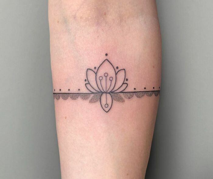 Elegant lotus armband tattoo design with intricate dot work.