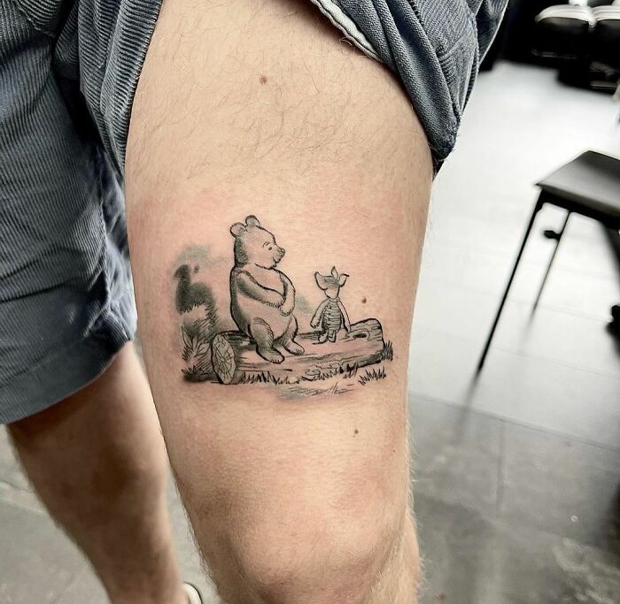 Arm tattoo featuring cartoon characters sitting on a log, inspired by childhood favorites.