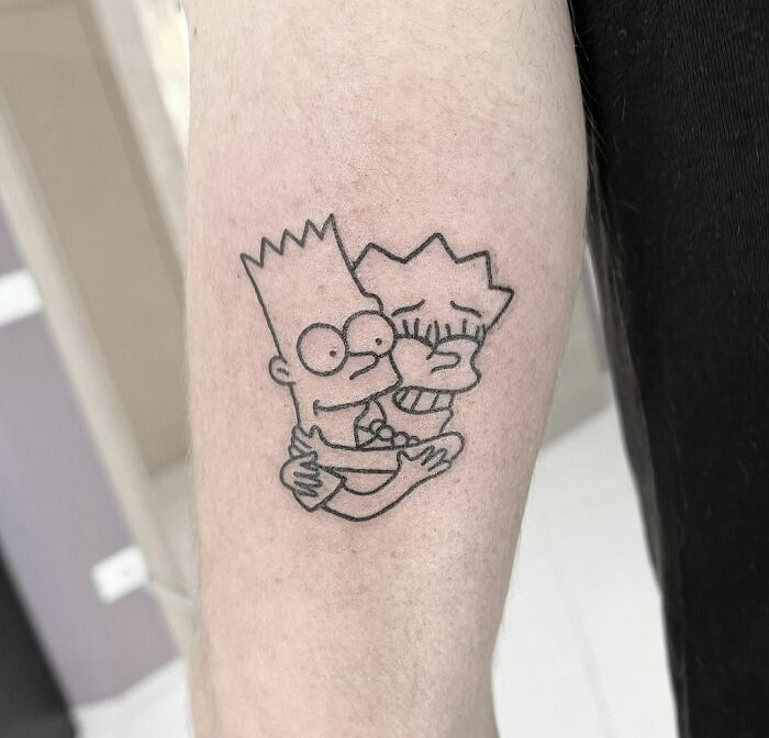 Cartoon tattoo of two popular animated characters embracing on an arm.