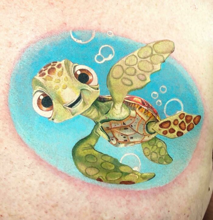 Cartoon tattoo of a smiling sea turtle in vibrant colors, inspired by animated shows, with bubbles in the background.
