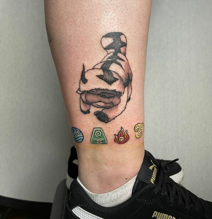 Cartoon tattoo inspired by a popular animated show with symbols of elements below.