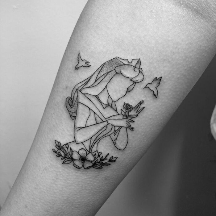Cartoon tattoo of Aurora from "Sleeping Beauty" holding a flower, capturing a nostalgic essence.