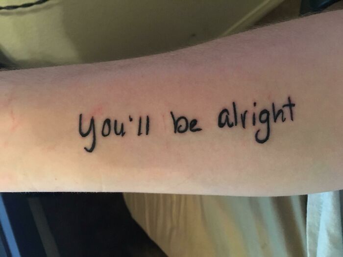 Arm with "you'll be alright" word tattoo, showcasing a simple ink design.