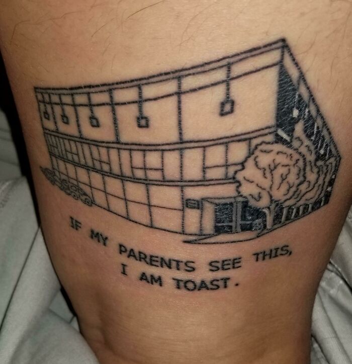 Line art building tattoo with caption "If my parents see this, I am toast" on skin, showcasing unique word tattoo idea.