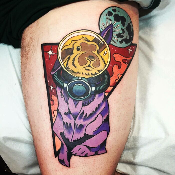 Colorful pet tattoo of a guinea pig in a spacesuit, celebrating furry friends with a cosmic theme.