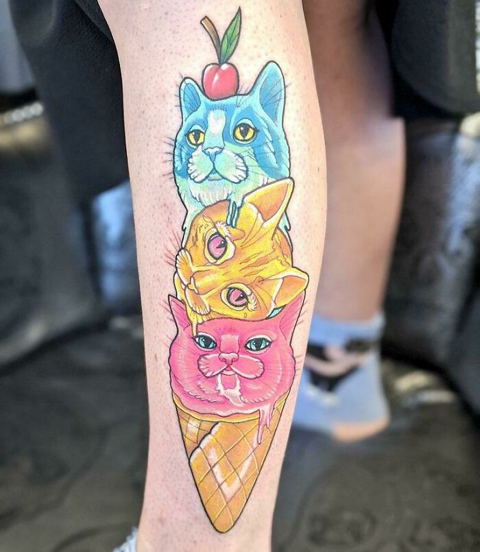 Colorful pet tattoo of cats stacked like an ice cream cone on a person's leg.