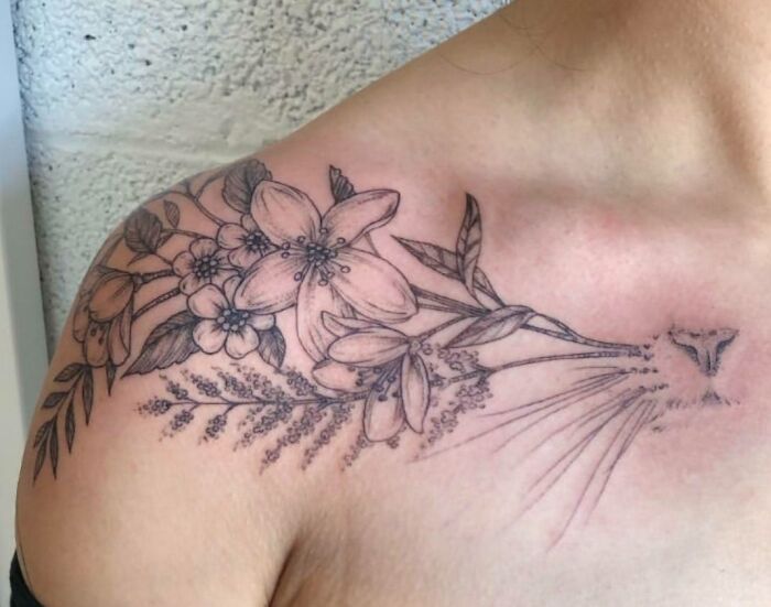 Floral pet tattoo on shoulder with hidden animal face, celebrating furry friends.