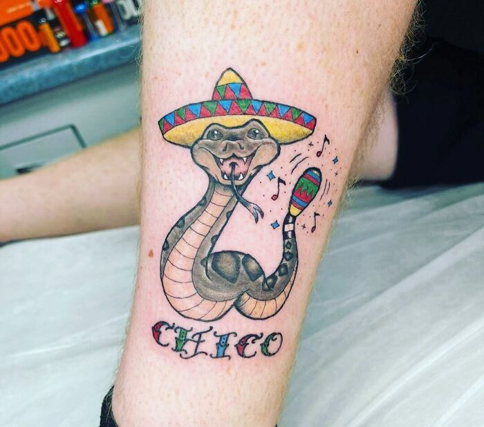Tattoo of a snake wearing a sombrero and holding a maraca, with "Chico" written below, representing adorable pet tattoos.
